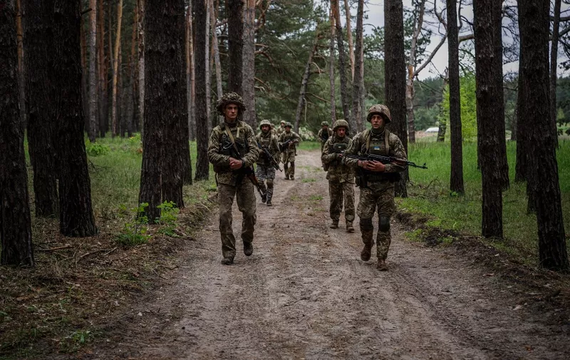 Ukrainian servicemen walk through a forest during a military exercise in the Kharkiv region on May 1, 2023, amid the Russian invasion of Ukraine. (Photo by Dimitar DILKOFF / AFP)