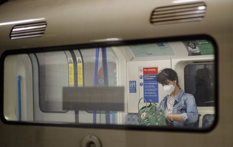 Commuters wear facemasks as they travel on the London Underground in London on June 12, 2020 as lockdown measures are eased during the novel coronavirus COVID-19 pandemic. (Photo by Tolga Akmen / AFP)