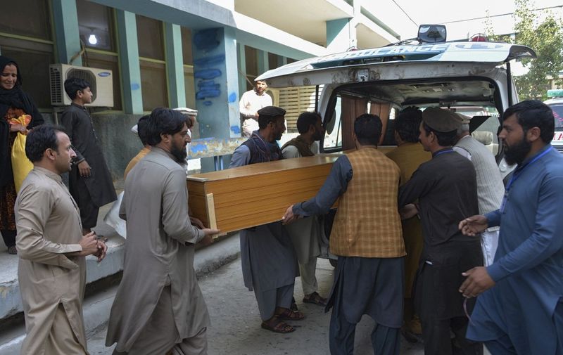 Relatives carry the coffin of a victim, who was killed in a stampede, outside a mortuary in Jalalabad on October 21, 2020. - At least 11 women were killed on October 21 in a stampede at a stadium in eastern Afghanistan where thousands had gathered to apply for visas at a nearby Pakistan consulate, officials said. (Photo by NOORULLAH SHIRZADA / AFP)