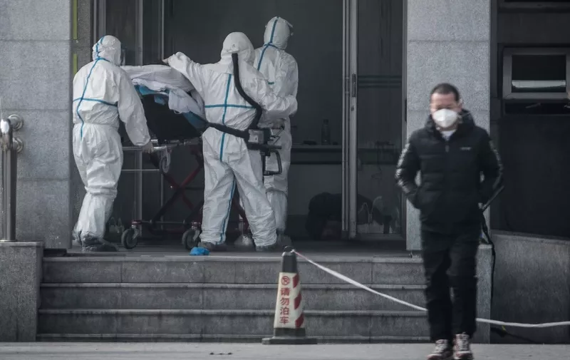 (FILES) This file photo taken on January 18, 2020 shows medical staff members carrying a patient into the Jinyintan hospital, where patients infected by a mysterious SARS-like virus are being treated, in Wuhan in China's central Hubei province. - A mysterious SARS-like virus has spread around China -- including to Beijing -- authorities said on January 20, 2020, fuelling fears of a major outbreak as millions begin travelling for the Lunar New Year in humanity's biggest migration. (Photo by STR / AFP) / China OUT