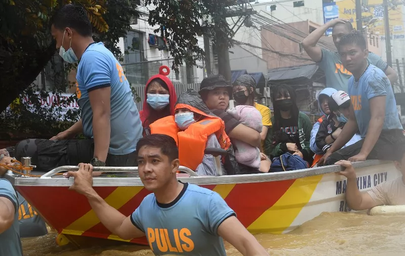 Rescuers evacuate residents from their flooded homes after Typhoon Vamco hit, in Marikina City, suburban Manila on November 12, 2020. (Photo by Ted ALJIBE / AFP)