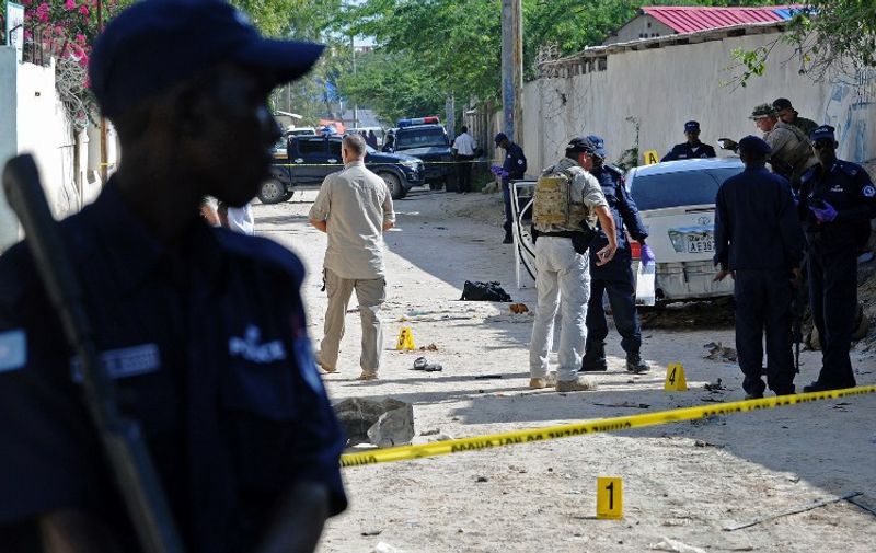 Security officers investigate the scene of a car bomb which killed Somali journalist Hindiyo Haji Mohamed in the Hodan neighbourhood of Mogadishu on December 3, 2015.
Mohamed died after a bomb believed to have been attached to her car was remotely detonated, police and witnesses said. The victim was a prominent local journalist working with Somali National Television and Radio Mogadishu. / AFP / MOHAMED ABDIWAHAB