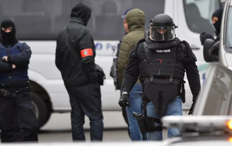 Security forces personnel walk past during ongoing operations in the Molenbeek district of Brussels on November 16, 2015. Belgian police launched a major new operation in the Brussels district of Molenbeek, where several suspects in the Paris attacks had previously lived, AFP journalists said. Armed police stood in front of a police van blocking a street in the run-down area of the capital while Belgian media said officers had surrounded a house. Belgian prosecutors had no immediate comment.AFP PHOTO / BELGA PHOTO / BENOIT DOPPAGNE

==BELGIUM OUT== / AFP / BELGA / BENOIT DOPPAGNE