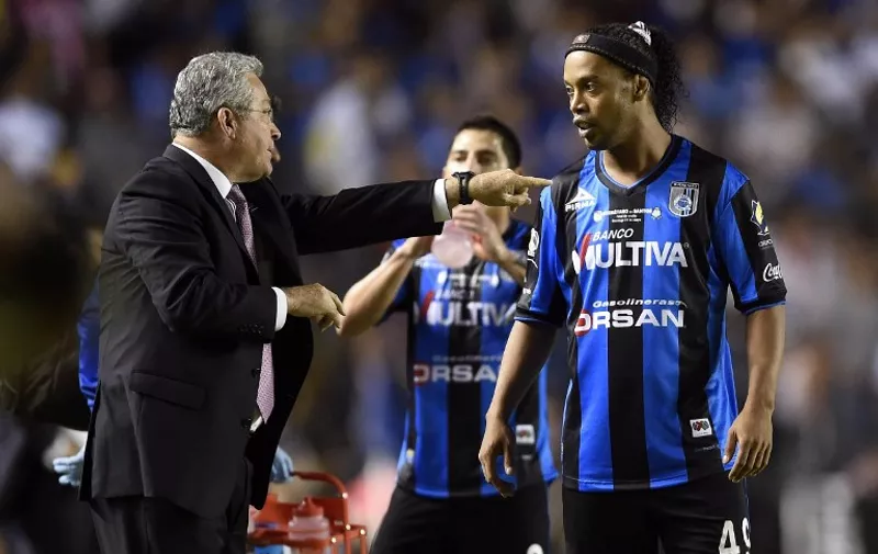 Manuel Vucetich coach of Queretaro gives instructions to Ronaldinho during their Mexican Clasura 2015 finals tournament match in Queretaro, Mexico, on May 31, 2015. AFP PHOTO/ALFREDO ESTRELLA