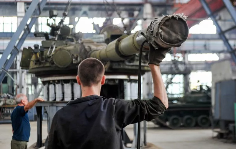 Workers work to upgrade T-80 tanks at Malyshev Tank Factory in the north-eastern Ukrainian city of Kharkiv on July 13, 2015, to be handed to Ukrainian forces in the east of the country.  AFP PHOTO/ SERGEY BOBOK