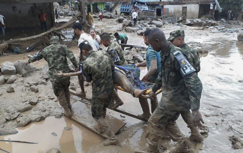 Handout picture released by the Colombian Army press office showing soldiers carrying a corpse following mudslides caused by heavy rains, in Mocoa, Putumayo department, on April 1, 2017.
Mudslides in southern Colombia -caused by the rise of the Mocoa River and three tributaries- have claimed at least 16 lives and injured some 65 people following recent torrential rains, the authorities said.   / AFP PHOTO / EJERCITO DE COLOMBIA / HO / RESTRICTED TO EDITORIAL USE - MANDATORY CREDIT AFP PHOTO /  EJERCITO DE COLOMBIA - NO MARKETING - NO ADVERTISING CAMPAIGNS - DISTRIBUTED AS A SERVICE TO CLIENTS