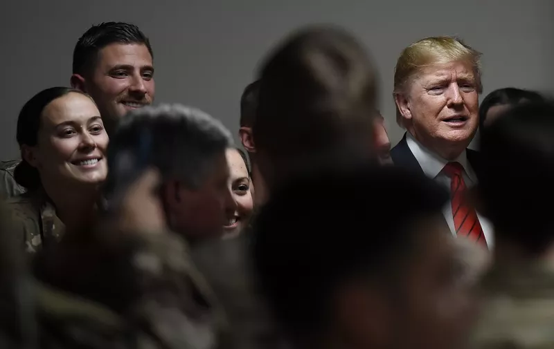 US President Donald Trump poses for pictures with soldiers during a surprise Thanksgiving day visit with US troops stationed at Bagram Air Field, on November 28, 2019 in Afghanistan. (Photo by Olivier Douliery / AFP)