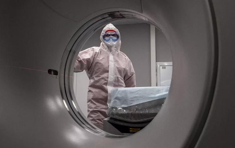 A medical worker wearing protective equipment stands by a computed tomography (CT) scanner at a new hospital built to treat coronavirus patients outside the village of Golokhvastovo  on April 23, 2020. - The 800-bed hospital, 70 kilometres (40 miles) south of Moscow, was inspired by a coronavirus facility in the Chinese province of Wuhan, officials said, and was built in a month. The complex is equipped with a lab and a dormitory for staff. (Photo by Yuri KADOBNOV / AFP)