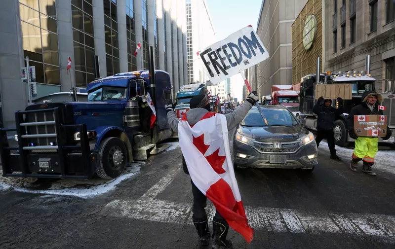 A person holds a sign reading "Freedom" as truckers and supporters continue to protest against mandates and restrictions related to Covid-19 vaccines in Ottawa, Ontario, Canada, on February 5, 2022. - Protesters again poured into Toronto and Ottawa early on February 5 to join a convoy of truckers whose occupation of Ottawa to denounce Covid vaccine mandates is now in its second week. (Photo by Dave Chan / AFP)