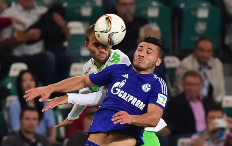 Schalke's defender Sead Kolasinac vies with Wolfsburg's Dutch striker Bas Dost (L) during the German first division Bundesliga football match VfL Wolfsburg vs FC Schalke 04 in Wolfsburg, northern Germany, on August 28, 2015.  AFP PHOTO / JOHN MACDOUGALL

RESTRICTIONS: DURING MATCH TIME: DFL RULES TO LIMIT THE ONLINE USAGE TO 15 PICTURES PER MATCH AND FORBID IMAGE SEQUENCES TO SIMULATE VIDEO. 
== RESTRICTED TO EDITORIAL USE ==
FOR FURTHER QUERIES PLEASE CONTACT DFL DIRECTLY AT + 49 69 650050.