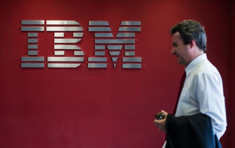 (FILES) In this file photo taken on September 14, 2012, a man passes by a logo at IBM office in Hortolandia, about 100km north from Sao Paulo, Brazil. - IBM said on October 28, 2018 it has reached a deal to buy software company Red Hat for USD 34 billion, a move the computing giant said would enhance its cloud offerings, a key area of growth. (Photo by Yasuyoshi CHIBA / AFP)