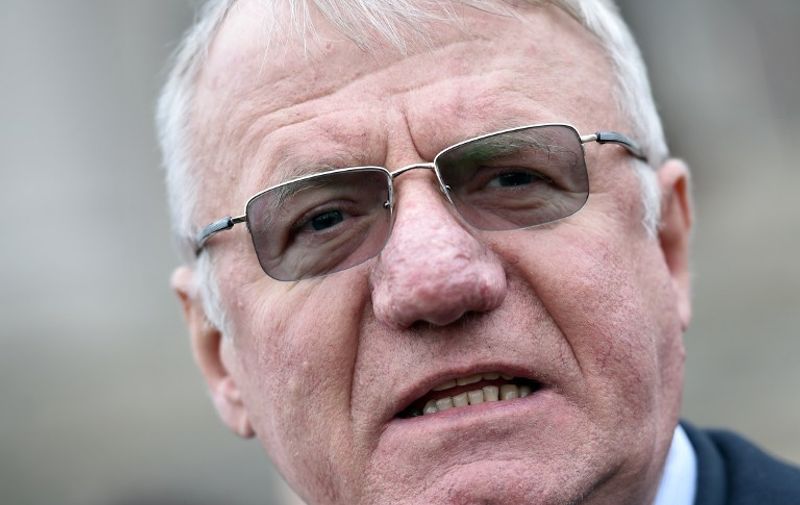 Serbian nationalist politician Vojislav Seselj speaks to journalists in front of the Serbian parliament building in Belgrade on January 23, 2015. Seselj and some of his party officials gathered in front of the Parliament to demand the resignation of Serbian President Tomislav Nikolic. Seselj was temporarily released from custody in mid-November while awaiting a verdict from the International Criminal Tribunal for former Yugoslavia (ICTY). The tribunal is judging Seselj's role in war crimes committed in Croatia and Bosnia in 1990s, and temporarily freed him for cancer treatment ahead of a ruling. AFP PHOTO / ANDREJ ISAKOVIC / AFP / ANDREJ ISAKOVIC