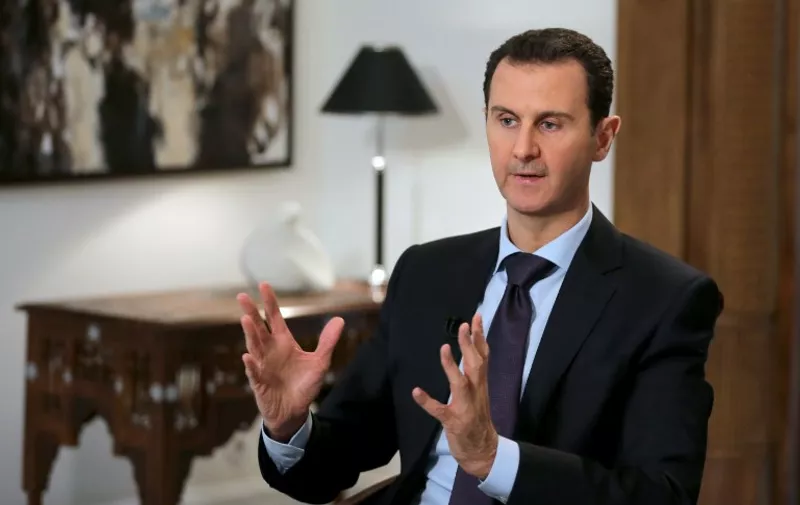 Syrian President Bashar al-Assad gestures during an exclusive interview with AFP in the capital Damascus on February 11, 2016.  / AFP / JOSEPH EID