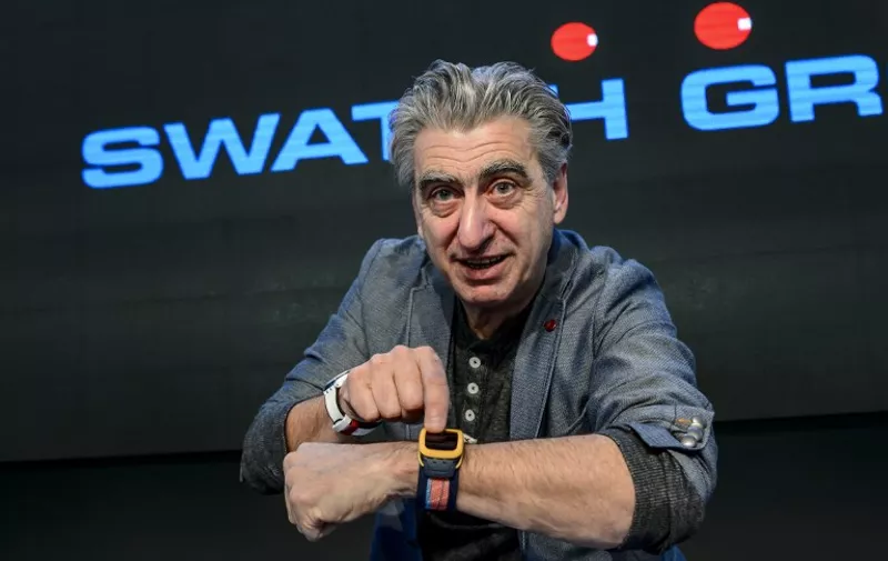 Swiss watchmaker Swatch Group CEO Nick Hayek shows the new Swatch Touch Zero One wrist watch during a press conference to present annual results of the worlds number one watchmaker on March 12, 2015 in Corgemont.  AFP PHOTO / FABRICE COFFRINI