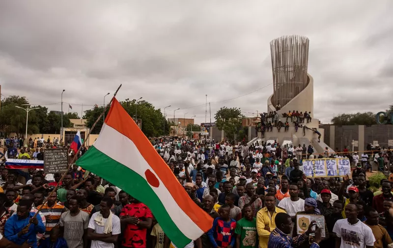 Protesters hold a Niger flag during a demonstration on independence day in Niamey on August 3, 2023. Hundreds of people backing the coup in Niger gathered on August 3, 2023 for a mass rally in the capital Niamey with some brandishing giant Russian flags.
The demonstrators converged at Concertation Square in the heart of the city, following a call by a coalition of civil society associations on a day marking the country's 1960 independence from France. (Photo by AFP)