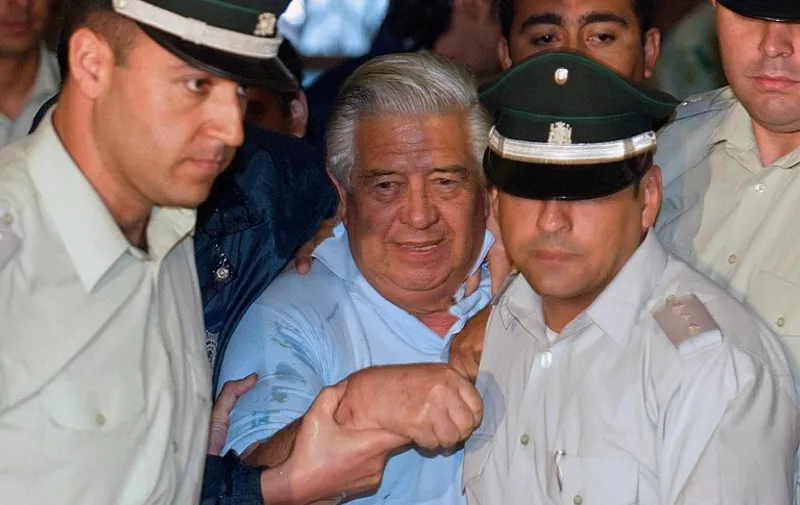 (FILES) Picture taken on January 28, 2005 in Santiago of police officers guarding General (retired) Manuel Contreras (C), founder of Gen. Augusto Pinochet's dictatorship (1973-1990) secret police (DINA), upon his arrival in court. Contreras died on August 7, 2015 at age 86.     AFP PHOTO/MARTIN BERNETTI