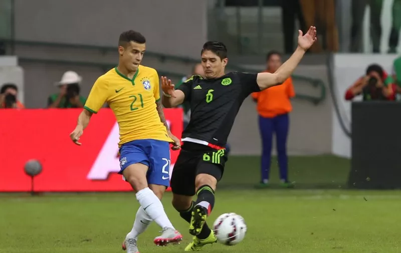 Brazil's Philipe Coutinho (L) vies for the ball with Mexico's Javier Guemez during a friendly football match in preparation for the Copa America Chile 2015 at Allianz Parque stadium in Sao Paulo, Brazil, on June 7, 2015. AFP PHOTO / Rubens CHIRI