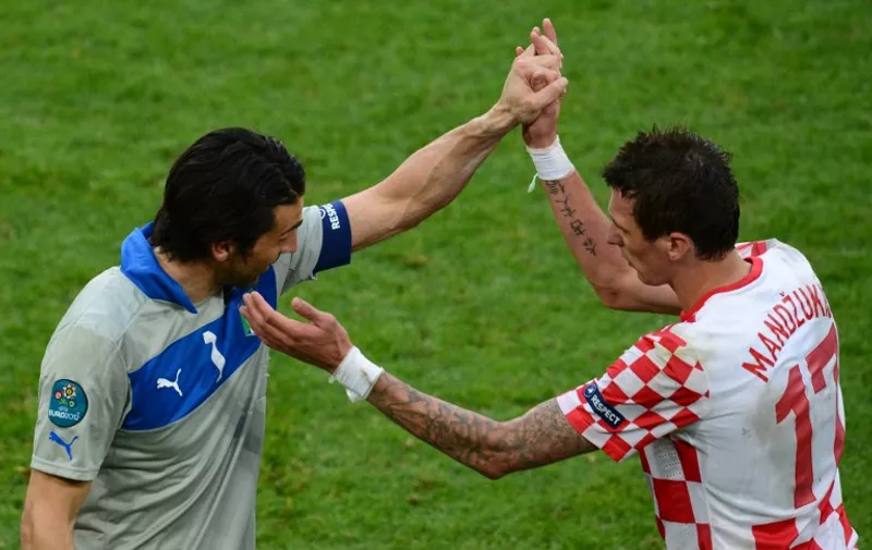 Italian goalkeeper Gianluigi Buffon (L) reacts with Croatian forward Mario Mandzukic at the end of the Euro 2012 championships football match Italy vs Croatia on June 14, 2012 at the Municipal Stadium in Poznan. The game ended in a draw 1-1.       AFP PHOTO/ DIMITAR DILKOFF