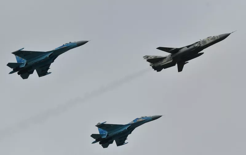 Ukrainian SU-27 fighters escort an SU-24 fron-line bomber during an air force exercises on Starokostyantyniv military airbase on October 12, 2018. - The large-scale air force exercises with the United States and other NATO countries "Clear Sky 2018", which will run until October 19, are being held in western Ukraine. Some 700 troops are taking part, half of them from NATO member countries including the United States, Britain, the Netherlands, Poland and Romania. US aircraft including F-15C Eagle fighter planes, Boeing KC-135 air refueling tanker, C-130J Super Hercules military transport planes and drones will train with about 30 Ukrainian aircraft. (Photo by Genya SAVILOV / AFP)