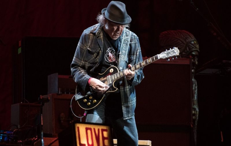 (FILES) In this file photo taken on July 06, 2018 Neil Young performs on stage for his first time in Quebec City during 2018 Festival d'Ete. - At 73 years old, Neil Young could be reminiscing about his legendary past, but the classic rocker instead has his sights set squarely on the planet's future with his latest album "Colorado." The album out October 25, 2019 sees Young, a long-time crusader for the environment, reunite with the loud, raggedy band Crazy Horse, which has recorded and toured on and off with the superstar for half a century. (Photo by Alice Chiche / AFP)