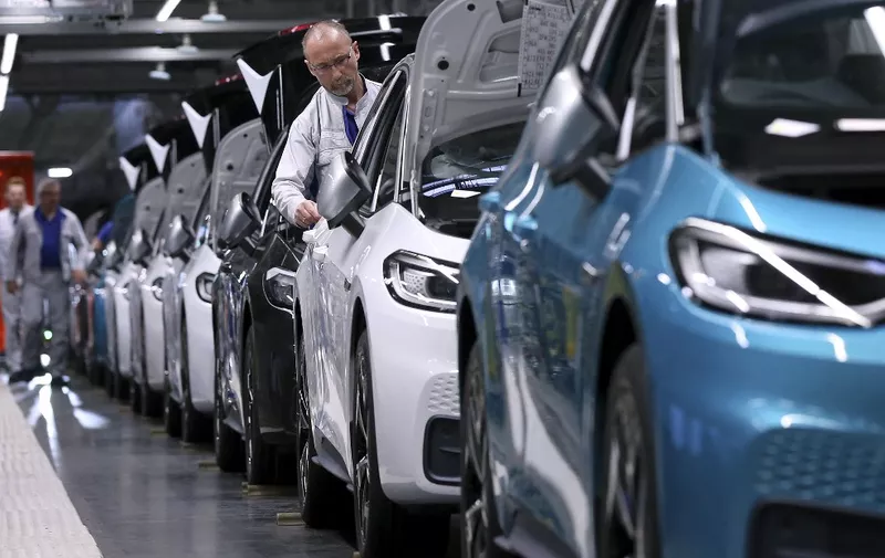 Employees of German car maker Volkswagen (VW) work on Volkswagen ID.3 electric car models at an assembly line of the Volkswagen car factory in Zwickau, eastern Germany, on February 25, 2020. (Photo by RONNY HARTMANN / AFP)