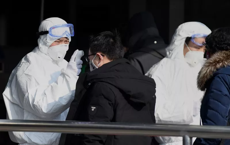 Travellers are checked by security personnel wearing hazardous material suits at the entrance to the underground train station in Beijing on January 24, 2020, to help stop the spread of a deadly SARS-like virus which originated in the central city of Wuhan. - China sealed off millions more people near the epicentre of a virus outbreak on January 24, shutting down public transport in an eighth city in an unprecedented quarantine effort as the death toll from the disease climbed to 25. (Photo by Noel Celis / AFP)