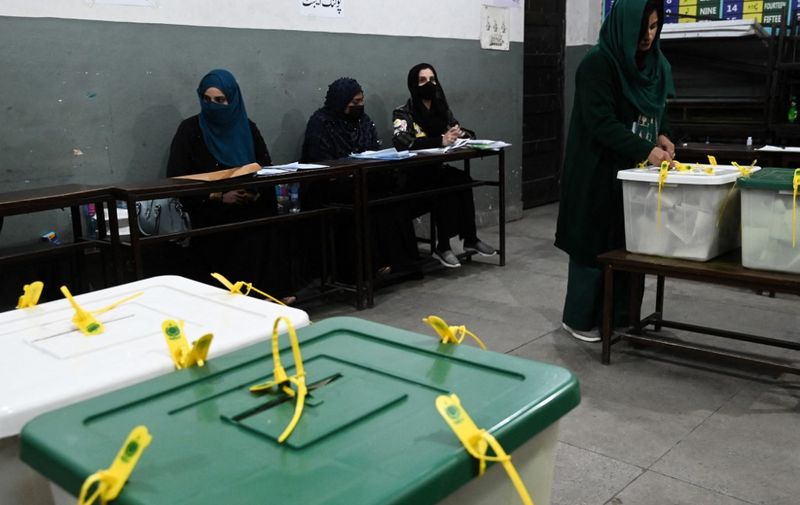 An election official seals ballot boxes after polls close at a polling station during Pakistan national election in Lahore on February 8, 2024. Pakistan suspended mobile phone and data services nationwide on February 8 for election day, in a move a digital rights group said was "inherently undemocratic". (Photo by Aamir QURESHI / AFP)