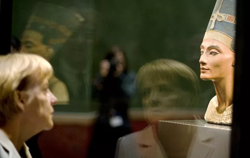 German Chancellor Angela Merkel looks at 3,400-year-old Egyptian beauty Queen Nefertiti as she visits Berlin's "Neues Museum" (New Museum) during the official opening on October 16, 2009. The Museum is to be re-opened to the public on October 17, 2009. After around ten years of planning, restoration and rebuilding lead by British architect David Chipperfield, the Neues Museum, heavily damaged and partly destroyed in the Second World War and still ruin at the time of German reunification, has been rebuilt and its remaining parts carefully restored. AFP PHOTO Bundesregierung / GUIDO BERGMANN