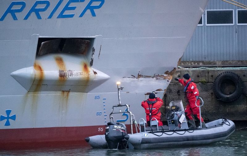 Personnel from the Swedish Coast Guard investigate the damaged ship Scot Carrier in the port of Ystad, Sweden, on December 14, 2021. - Sweden arrested on December 13, 2021 two people after a fatal early morning collision between a Danish and British ship off the southern Swedish coast, prosecutors said. (Photo by Johan NILSSON / TT NEWS AGENCY / AFP) / Sweden OUT
