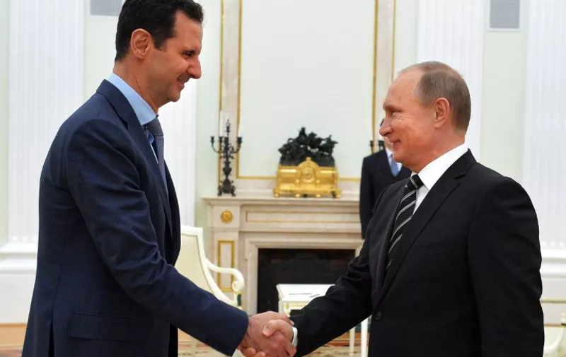 Russian President Vladimir Putin (R) shakes hands with his Syrian counterpart Bashar al-Assad (L) during their meeting at the Kremlin in Moscow on October 20, 2015. Syria's embattled President Bashar al-Assad made a surprise visit to Moscow on October 20 for talks with Russian President Vladimir Putin, his first foreign trip since the conflict erupted in 2011.  AFP PHOTO / RIA NOVOSTI / KREMLIN POOL / ALEXEY DRUZHININ