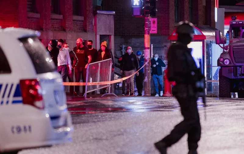 People are evacuated from the Ubisoft office as Montreal police respond to a possible hostage-taking at the Ubisoft office in the Mile End, on the corner of Saint-Laurent and Saint-Viateur Sts., in Montreal, Quebec on November 13, 2020. - A major police operation was underway in Montreal Friday at offices of French video game company Ubisoft in response to what media said was a possible hostage-taking, but no threat had yet been found. (Photo by Andrej Ivanov / AFP)