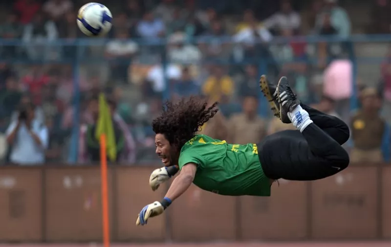 Former Colombian goolkeeper Rene Higuita kicks the ball to save a goal during an exhibition match between the Brazilian Masters and Indian All Stars in Kolkata on December 8, 2012. The Brazilian team won the match by 3-1. AFP PHOTO/ Dibyangshu SARKAR