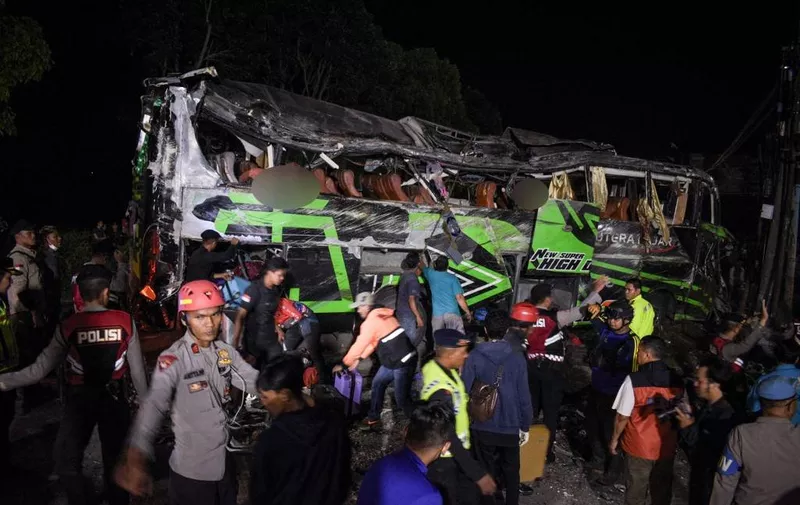 Officers check the debris and belongings of passengers after a bus crash that killed 11 people, according to local police, in Subang, West Java, on May 11, 2024. (Photo by Timur MATAHARI / AFP)