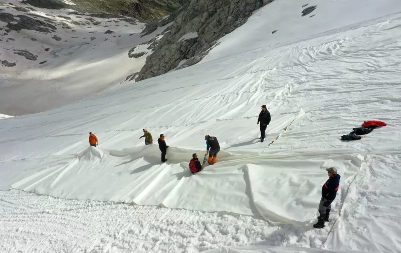 An aerial photo taken on June 19, 2020 shows workers covering with huge geotextile sheets the Presena glacier (2700m-3000m) on the Val di Sole near Pellizzano in Trentino, northern Italy, in order to delay snow melting on skiing slopes. (Photo by MIGUEL MEDINA / AFP)