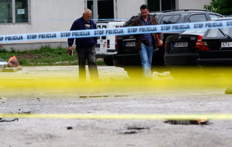 Police investigators look at damaged vehicles on parking lot in front of a police station in the central Bosnian town of Bugojno on June 27, 2010. A powerful blast ripped through the police station on June 27, killing a policeman and wounding six other officers. Police have arrested several people suspected of involvement in the explosion. AFP PHOTO / ELVIS BARUKCIC (Photo by ELVIS BARUKCIC / AFP)