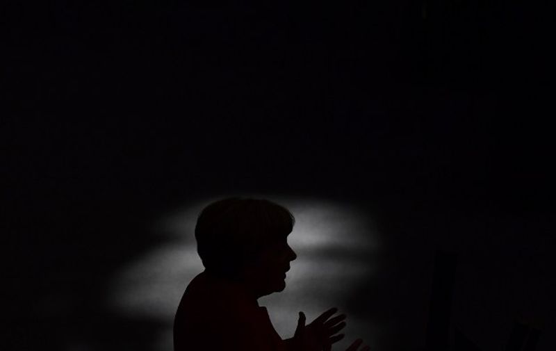 (FILES) This file photo taken on September 7, 2016 shows German Chancellor Angela Merkel being silhouetted as she gives a speech during a session of the German Bundestag (lower house of parliament) in Berlin.
Merkel will stand for re-election as leader of the conservative Christian Democratic Union (CDU) party during the party's congress taking place from December 5 to 7, 2016 in Essen, western Germany. / AFP PHOTO / TOBIAS SCHWARZ
