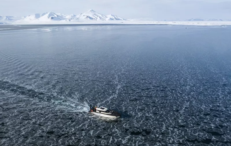 This aerial view image taken on May 3, 2022 shows the Kvitbjorn (Polar Bear, in Norwegian), a hybrid touristic boat, combining a diesel motor and electric batteries, as it makes its way in the sea ice in the Borebukta Bay, located at the northwestern side of Isfjorden, in Svalbard Archipelago, northern Norway. (Photo by Jonathan NACKSTRAND / AFP)