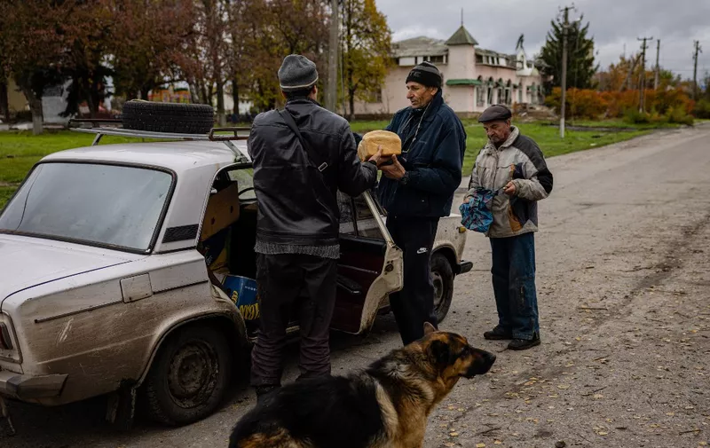 Local residents buy a bread in the village of Drobysheve in eastern Ukraine's Donetsk region, on October 28, 2022, after the liberation of the area. (Photo by Dimitar DILKOFF / AFP)