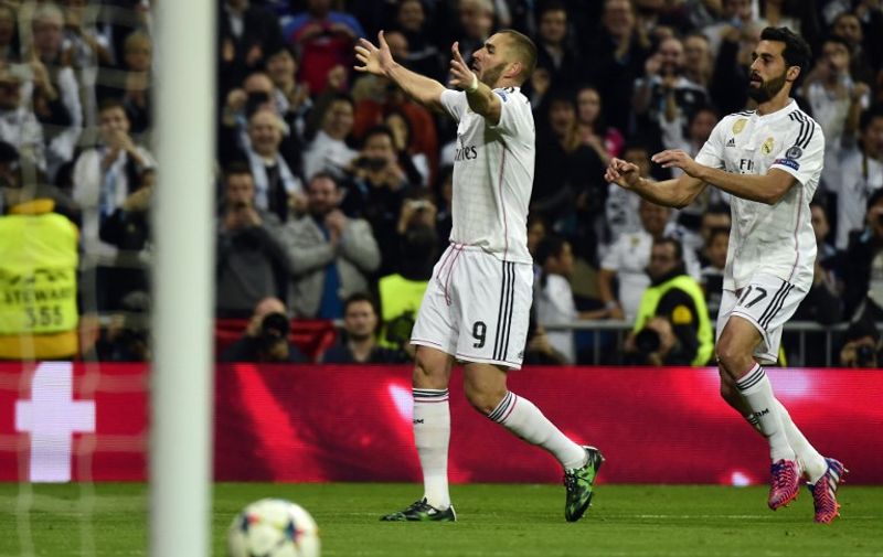 Real Madrid's French forward Karim Benzema celebrates after scoring next to Real Madrid's defender Alvaro Arbeloa (R) during the UEFA Champions League round of 16 second leg football match Real Madrid CF vs FC Schalke 04 at the Santiago Bernabeu stadium in Madrid on March 10, 2015.     AFP PHOTO/ GERARD JULIEN