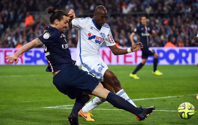 Paris Saint Germain Swedish forward Zlatan Ibrahimovic vies with Marseille&#8217;s French defender Rod Fanni (R) during the French L1 football match between Marseille (OM) and Paris Saint Germain (PSG) at the Velodrome stadium in Marseille, southern France, on April 5, 2015. AFP PHOTO/ ANNE-CHRISTINE POUJOULAT