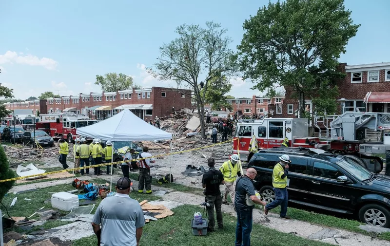 BALTIMORE, MD - AUGUST 10: First responders search for survivors at the scene of an explosion on August 10, 2020 in Baltimore, Maryland. Early reports indicate that a gas leak may have caused the massive explosion that leveled three homes, causing multiple injuries and at least one fatality.   Michael A. McCoy/Getty Images/AFP