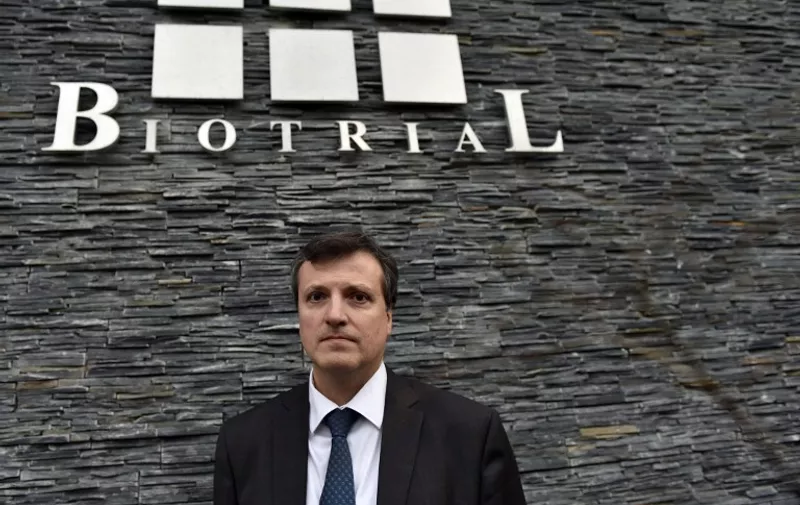 Biotrial general director Francois Peaucelle poses in front of the Biotrial logo at the society headquarters, in Rennes, western France, on January 16, 2016.
French authorities launched three investigations today at a research laboratory in the northwestern city of Rennes into a drug trial that left one person brain-dead and three others facing potentially irreversible brain damage. The study was a Phase I clinical trial, in which a drug is tested on humans for the first time, after likely tests on animals and in the laboratory to ensure its safety. France's national drug safety body (ANSM) confirmed it was the worst-ever incident to have taken place in a drug trial in the country. / AFP / LOIC VENANCE