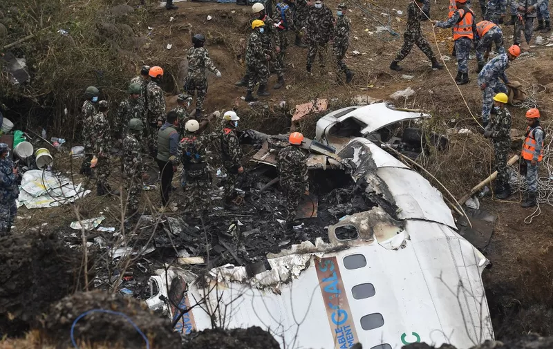Rescuers inspect the wreckage at the site of a Yeti Airlines plane crash in Pokhara on January 16, 2023. - Nepal observed a day of mourning on January 16 for the victims of the nation's deadliest aviation disaster in three decades, with 67 people confirmed killed in the plane crash. (Photo by PRAKASH MATHEMA / AFP)