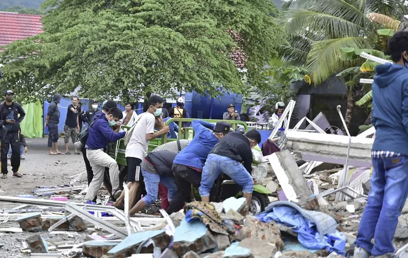 EDITORS NOTE: Graphic content / Rescuers search for survivors at a collapsed building in Mamuju city on January 15, 2021, after a 6.2-magnitude earthquake rocked Indonesia's Sulawesi island. (Photo by Firdaus / AFP)