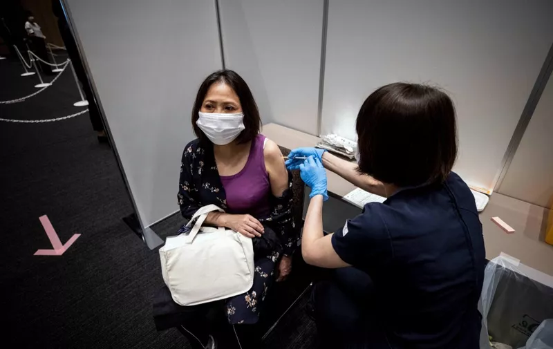 An employee of Japan's Mori Building Company, a property management firm, receives the Moderna coronavirus vaccine for Covid-19 during the company's workplace vaccination campaign in Tokyo on June 21, 2021. (Photo by Behrouz MEHRI / AFP)