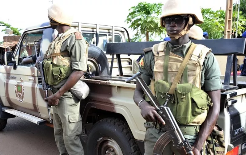 Armed soldiers stand next to a pickup truck on August 13, 2015 near the site in Mali's capital Bamako where a policeman and a civilian were wounded on the night of August 12 when gunmen opened fire on a police outpost. The attackers arrived at a busy bus station in a taxi before opening fire on the police post, injuring two people, Interior Minister Sada Samake said. "This is an isolated act," Samake said. "We have opened an investigation." AFP PHOTO / HABIBOU KOUYATE / AFP PHOTO / HABIBOU KOUYATE