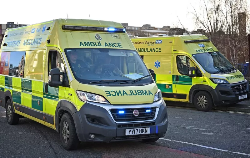 A member of the military accompanies an ambulance worker in an ambulance responding with blue lights in Leeds, northern England on January 11, 2023. The UK government on January 10, 2023 introduced proposals to make "minimum safety levels" compulsory during strikes, prompting angry unions to accuse ministers of "criminalising" industrial action and threaten legal challenges. Ambulance workers in England and Wales walked out again today while nurses will follow suit again next week. (Photo by Paul ELLIS / AFP)