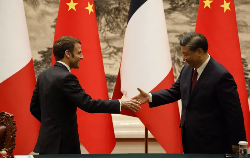 Chinas President Xi Jinping (R) shakes hands with his French counterpart Emmanuel Macron after the signing ceremony in Beijing on April 6, 2023. (Photo by Ludovic MARIN / AFP)