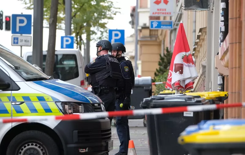 Policemen secure the area around the site of a shooting in Halle an der Saale, eastern Germany, on October 9, 2019. - At least two people were killed in a shooting on a street in the German city of Halle, police said, adding that the perpetrators were on the run. "Early indications show that two people were killed in Halle. Several shots were fired. The suspected perpetrators fled in a car," said police on Twitter, urging residents in the area to stay indoors. (Photo by Sebastian Willnow / dpa / AFP) / Germany OUT