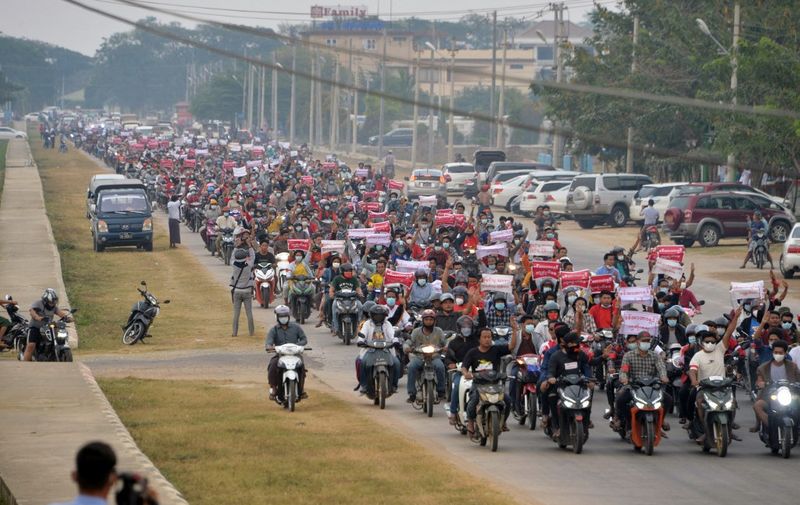Protesters ride scooters in a large convoy demonstration against the military coup in Naypyidaw on February 7, 2021. (Photo by STR / AFP)